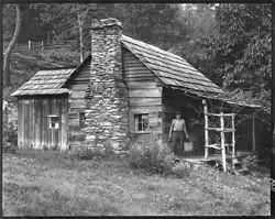 Log cabin with man near same, out of Pineola, North Carolina