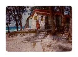 Margaret Howard standing in front of a house on a beach