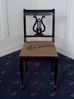 Straight-back chair with notes needlepoint design.
