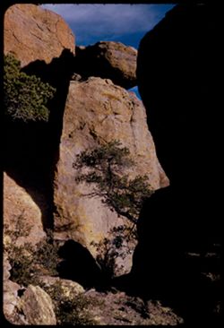 A balanced rock seen through gap betwwen two large rocks Massai Pt. Chiricahua