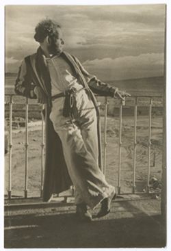 Item 0395. Eisenstein, wearing a striped bathrobe, leaning against a balcony railing.