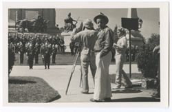 Item 44. In foreground, center, Eisenstein turning to look at photographer. Tissé in front of him at camera. Unidentified man to Tissé's left. In background, same military unit on steps of Monument.