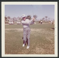 Hoagy Carmichael in mid swing on a golf course.