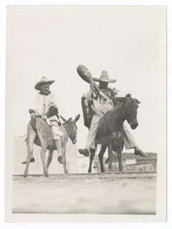 Item 0410d.  Various shots of Eisenstein and man seen in Items 398, 401-407 above, riding donkeys in courtyard of Hacienda. On back, stamped in blue: "AM PHOTO" and "82."