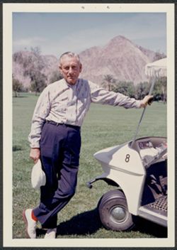 Hoagy Carmichael posing by golf cart.