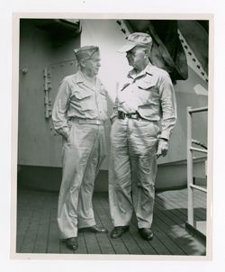 Two men stand aboard a ship