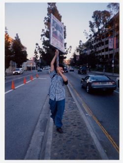 Street team member holding picket sign promoting Warren G