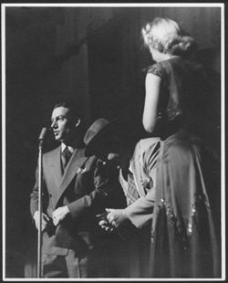 Hoagy Carmichael at a microphone, standing next to an unidentified man and woman.