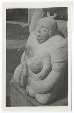 Item 58. Stone statue, modern, of mother and child. Portions of other statues visible in background.