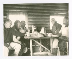 Roy Howard and others in a cabin