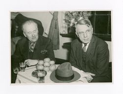 Roy Howard sits with a man