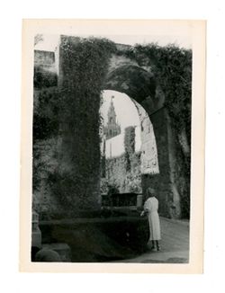 Woman stands by archway