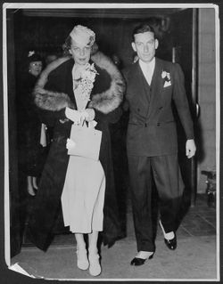 Hoagy Carmichael and Ruth Carmichael exiting a doorway after their wedding ceremony.