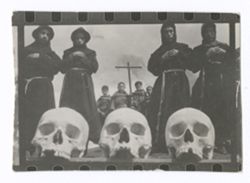 Item 0915. Three skulls in foreground, four monks immediately behind them, and another group of four monks, with a cross behind them, in the background. See Item 247-249 above.