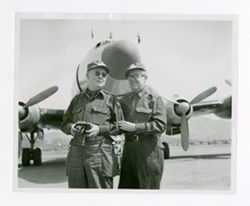 Roy Howard standing with man by plane