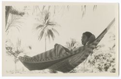 Item 0009. Profile shot of man seen in Items 8-8b above lying in the same hammock.