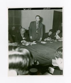 A man speaks in a meeting