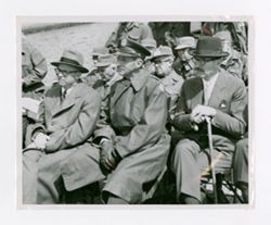 Roy Howard sitting with men