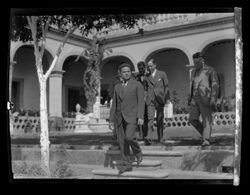 Item 0270a. Five unidentified men in business suits on a patio with arches and house behind them. Leaving the patio, descending stone steps into a garden (?)