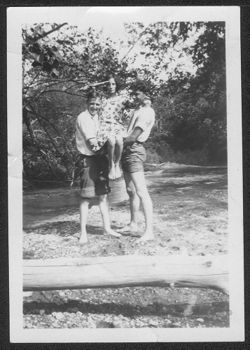 Two unidentified boys holding up Martha Carmichael, who is saluting.