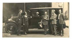 Roy Howard posing against a car with others