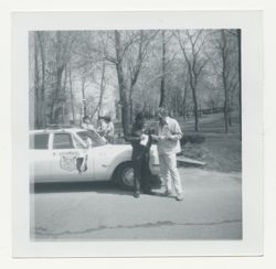Two men standing in front of police car