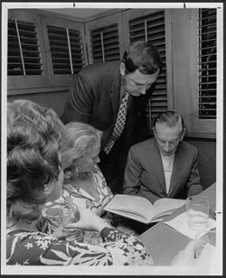 Hoagy Carmichael looking at book with Lou Scott(standing), Helene Bowman and Mrs. Stoll (far left), Hollywood.