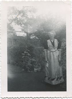 Unidentified older woman standing in garden