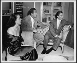 Hoagy Carmichael sitting with program guests Pat Dane (far left) and Sheldon Leonard, on the set of the Pantomime Quiz Time Show.
