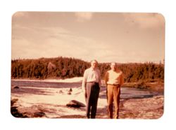 Two men standing by a river