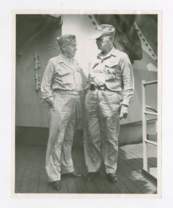 Two men stand aboard a ship