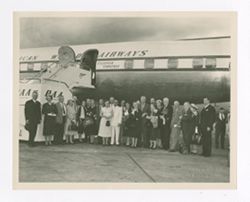 Group of people standing outside of an airplane