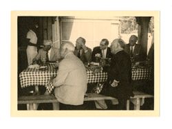 Men watch at picnic table