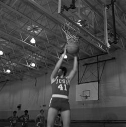 IU South Bend men's basketball player attempts to dunk ball, 1970s