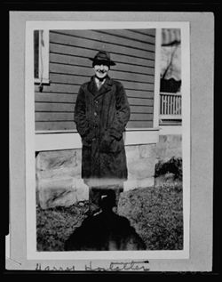 Harry Hostetter standing next to house, fall 1925.