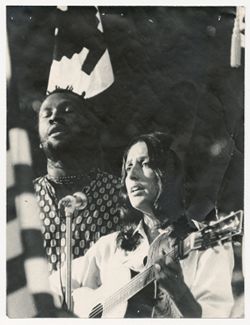 Woman and man singing at microphone
