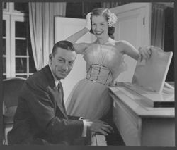 Hoagy Carmichael playing piano, with an unidentified woman standing beside him.