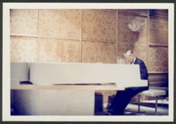 Hoagy Carmichael playing piano at Sherman Fairchild's home.