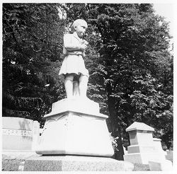 Little boy statue holding [long] flowers buttoned coat