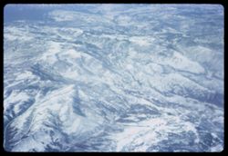 Snow-covered Rocky mountains below Pan-Am jet Los Angeles - London