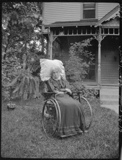 Old lady in chair, next door to Deam's (Mrs. Knapp)