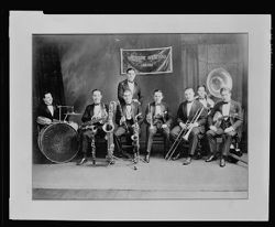 Eight members of the Wolverine Orchestra posing with instruments.