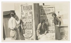 Item 0439a. Two similar shots of Alexandrov, Agustin Leiva, and Eisenstein with large posters. Unidentified woman at far right.