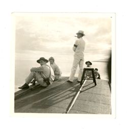 Men sitting and standing on a dock