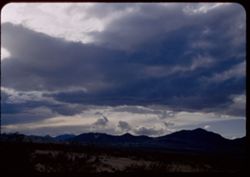 Storm clouds gather over Sierra Nevada. View is west from Ridgecrest-Trona road. California.