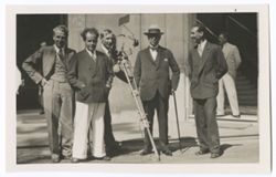 Item 34. From left, Alexandrov, Eisenstein, Tissé (with camera), President Rubio, Dr. Best Maugard. Standing in front of large building, two doorways in background, with unidentified people partially visible.