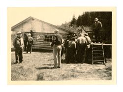 Group of men outside cabin