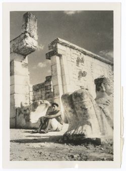 Item 0169. Entrance to upper temple, Temple of the Warriors. Chac-Mool at far right. At far left, the serpent's head seen in Items 167-168 above, with young Indigenous man seated on the ground in front of it.