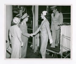 Man in military uniform greeting women