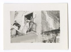 Item 0978. - 0978a. Alexandrov standing on a larger balcony with two young women.